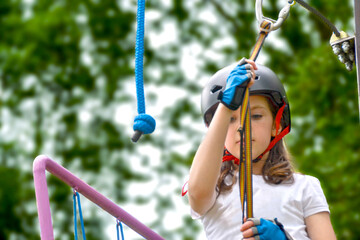 adventure climbing high wire park - people on course in mountain helmet and safety equipment. High quality photo. High quality photo