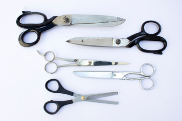 To the right, we see professional hairdressing scissors with a shiny metallic finish. The intricate finger rest indicates precision cutting. Perfect for hairstylists and barbers.