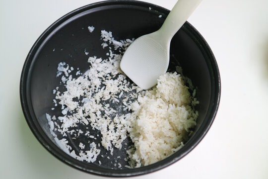the remaining dried rice in the magic com. stale rice leftover in the rice cooker pot.