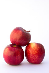 Three Red Apples in the white background. Apples also provide copper to produce red blood cells, vitamin A to maintain healthy organ functioning, vitamin E to reduce inflammation.