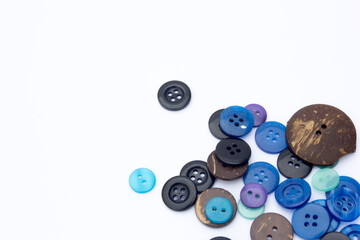 An assortment of buttons—ranging from shades of blue, black, and brown—displayed against a white backdrop. Perfect for sewing, fashion, or creative projects.