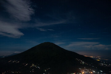 Night view of Mount Merbabu National Park with city light on the valley