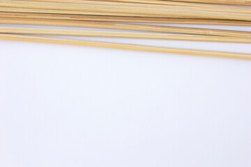 Minimalistic Wooden Skewers: A group of light-toned wooden skewers arranged in an overlapping pattern against a clean white backdrop. Perfect for backgrounds, textures, or eco-friendly design elements