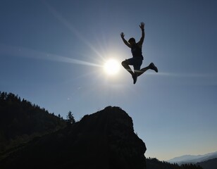 Silhouette of a Man Jumping Mid-Air Against the Sun on a Mountain Ridge