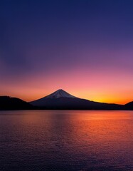 夕日が富士山をオレンジ色に染め、空は赤と紫のグラデーションに包まれている。富士山のシルエットが際立ち、神秘的な雰囲気を醸し出している