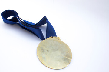 Customizable Recognition Badge: A polished gold medal on a textured blue ribbon, ideal for representing honor, success, or competition. The unmarked surface invites customization.