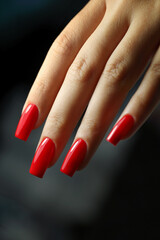 Red shiny and sexy manicure gel polish.
Woman manicured hands, stylish red nails