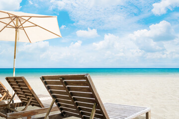 Beach chairs on sand beach with blue sky