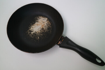 Old scratched non-stick pan isolated on white background. Pan peeling off. there is a possibility...