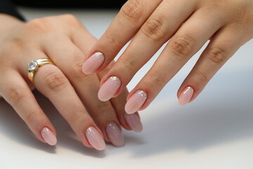 Beautiful nude manicure. Manicure with gel polish. Close-up of the hands of a young woman with a delicate nude 