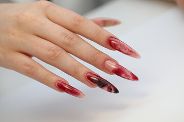 Closeup of elegant female hand with red stiletto nails . Long red nails