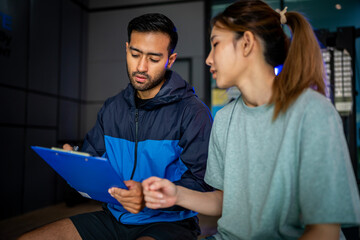 Asian man and woman working out, one is a trainer, the other is an exerciser.