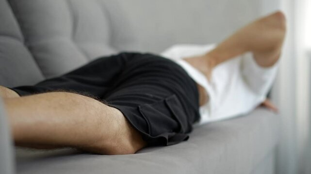 A young guy has back problems.
Back pain in a man.
The guy massages his back to relieve the pain.
Lower back pain.
Health, posture, back, massage