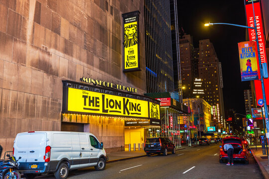 Exterior view of the Minskoff Theatre featuring 'The Lion King' musical signage on a quiet street in New York City at night. New York. USA. 