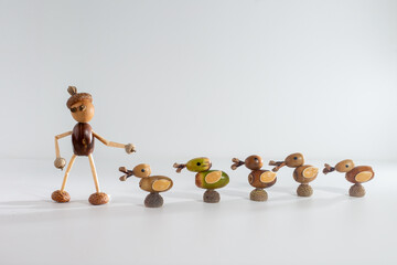Five handmade ducks made from acorns and twigs, aligned in a row. Unique nature art with one green and four brown ducks. Ideal for autumn decor, eco friendly crafts, and DIY inspiration