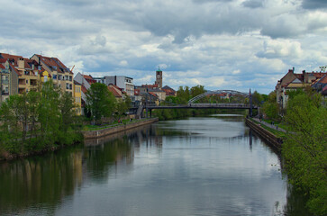 Fototapeta premium Landscape view of river Regnitz in down town of Bamberg,region Upper Franconia, Germany. Colorful houses along the river. Clouds reflected in tranquil water of the river. Travel and tourism concept