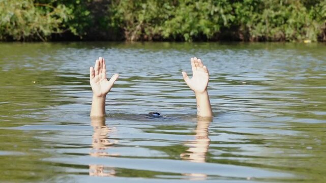 Little girl wearing swimming goggles swimming and diving in lake in summer