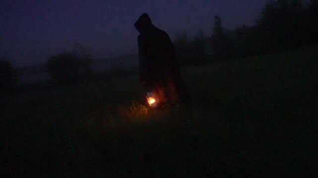fantasy Kerosene lamp in the fog carried by a man in a robe, halloween fairytale atmosphere