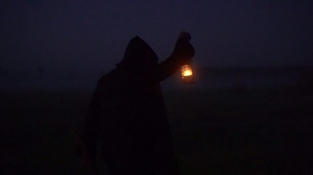 fantasy Kerosene lamp in the fog carried by a man in a robe, halloween fairytale atmosphere