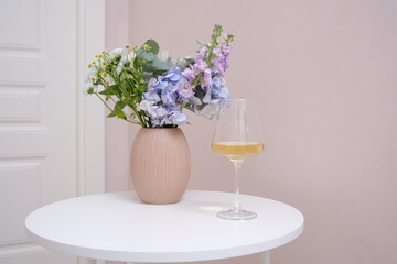 A Stylish Floral Arrangement with Elegant Wine Set Beautifully on a Dining Table