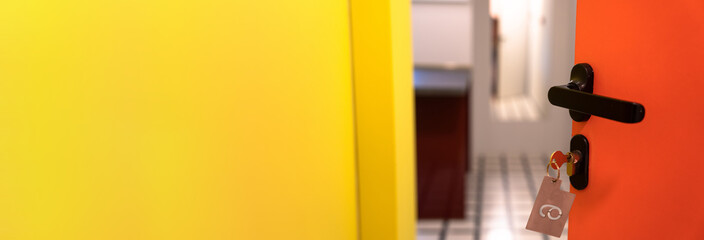 hotel room door half open, orange and yellow design, service industry concept