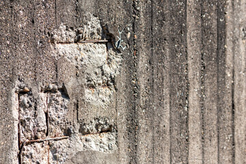 Broken concrete wall with details of ferroconcrete structure as reinforced concrete with metal skeleton shows damages and ailing and aging concrete wall or bunker protection in war time after attacks