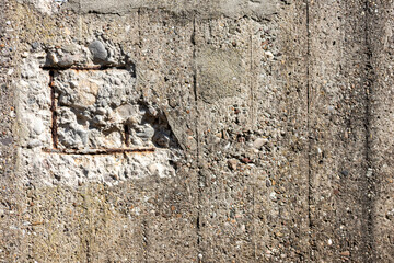 Broken concrete wall with details of ferroconcrete structure as reinforced concrete with metal skeleton shows damages and ailing and aging concrete wall or bunker protection in war time after attacks
