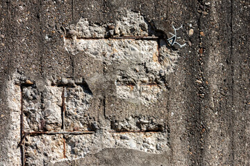Broken concrete wall with details of ferroconcrete structure as reinforced concrete with metal skeleton shows damages and ailing and aging concrete wall or bunker protection in war time after attacks