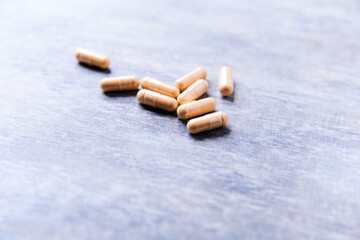 Lutein capsules. Dietary supplement on wooden background. Soft focus. Close up. Copy space.	