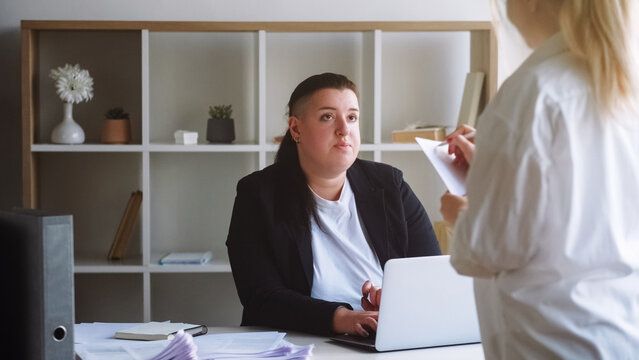 Job interview. Business meeting. Productive overweight woman executive director discussing project plan assigning tasks to workers in office.