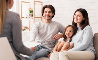 Happy Parents With Little Daughter Sitting Together At Psycholigist's Office After Successful...