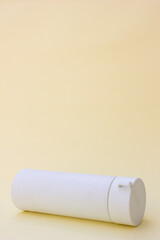 Featuring a sleek, minimalist design, this white tumbler stands out against a soft yellow background. Its clean lines and modern aesthetic make it ideal for lifestyle branding.