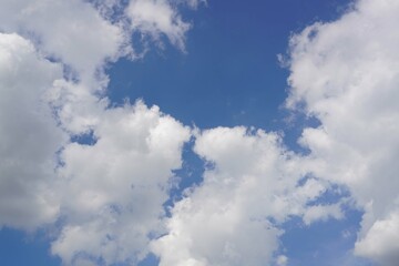 A blue sky with a white clouds with a sun light.