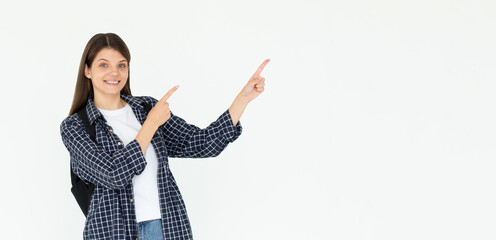 Hey look. Smiling pretty female model pointing fingers right at empty space and inviting to check...