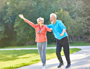 Fototapeta premium senior fitness woman man active sport exercise together running jogging hand celebrate celebration happy raised arm success victory team achievement teamwork winner up winning freedom healthy fit