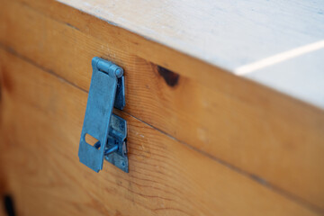 aged metal hasps for a padlock, affixed to a weathered wooden chest, symbolizing secrets buried in...