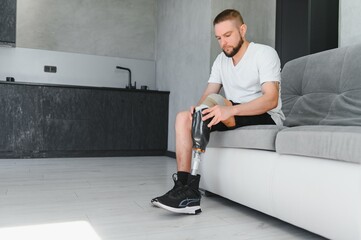 Portrait of a young man with a prosthetic leg at home