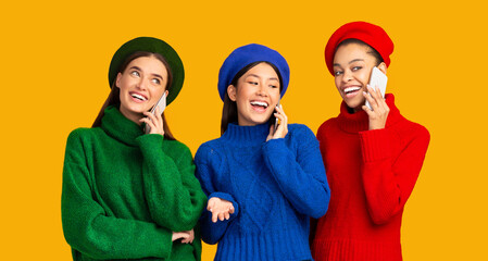 Mobile Phone Communication. Three Diverse Girls Talking On Cellphones Standing Over Yellow Studio Background. Panorama