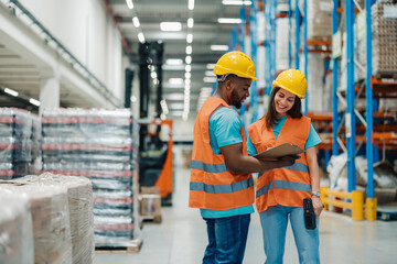 Diverse warehouse staff reviewing inventory data with technology support