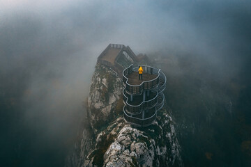 Valla Canyon. Valla Canyon stands in all its glory among the fog. A man in a yellow coat enjoys the view at the top of the canyon. Drone shot. Kastamonu, Turkey.