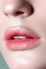 Naklejka premium Lips of young sensual woman with clear glowing skin closeup