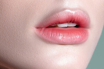 Naklejka premium Lips of young sensual woman with clear glowing skin closeup