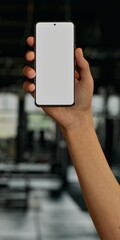 Asian young male using smartphone with a blank white screen. Gym, exercise, workout equipment apps mockup. Vertical phone orientation