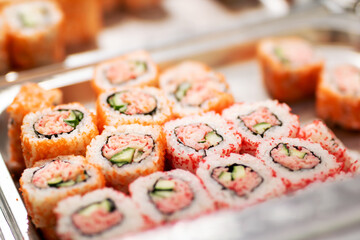 A tray filled with delicious sushi featuring crab and cucumber