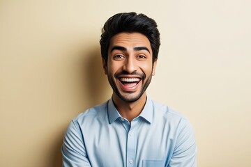 Obraz premium A Joyful Portrait of a Vibrant Young Middle-Eastern Man Showcasing His Bright Smile Against a Cream Background for Advertising and Creative Designs
