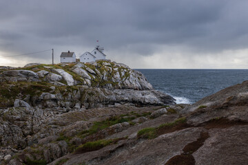 A lighthouse perched on a rugged cliff in the Lofoton Islands, Norway.