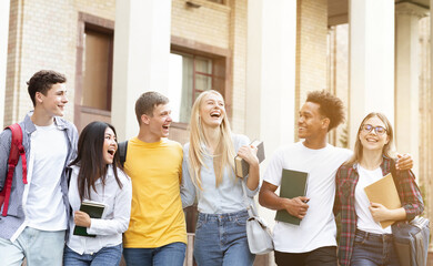 Happy students walking together in campus, having break in university