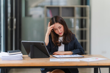 The Weight of Responsibility: A young businesswoman, engrossed in her work, contemplates the...