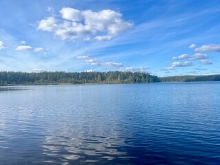 beautiful blue lake view, blue sky with white clouds reflections on the lake surface