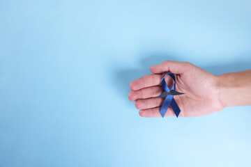 Prostate cancer awareness. Man with light blue ribbon as symbol of support on color background, top...